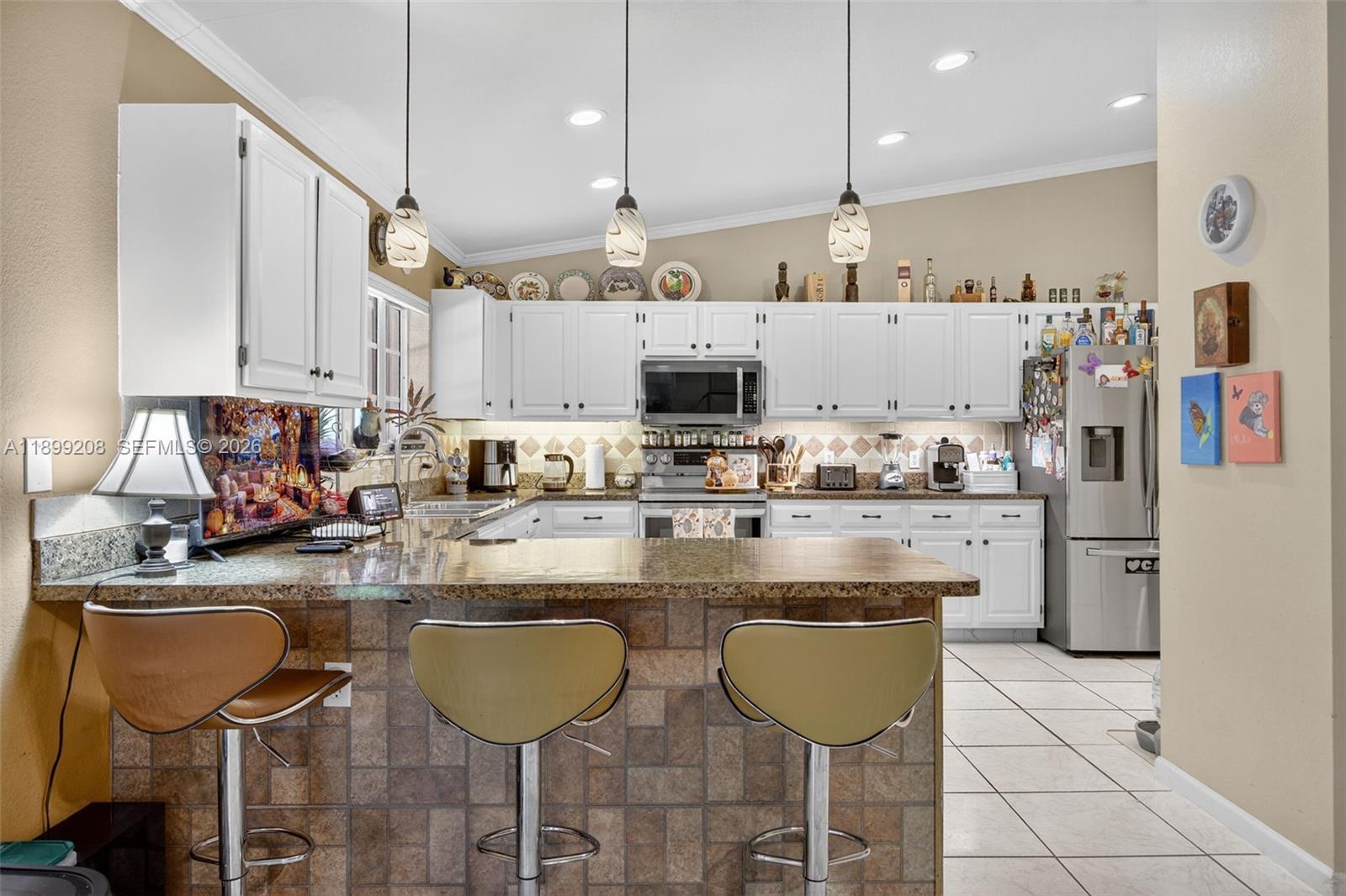 28241 Southwest 157th Court Homestead, FL 33033 - Photo 15 of 52 a kitchen with stainless steel appliances granite countertop a table chairs sink and cabinets