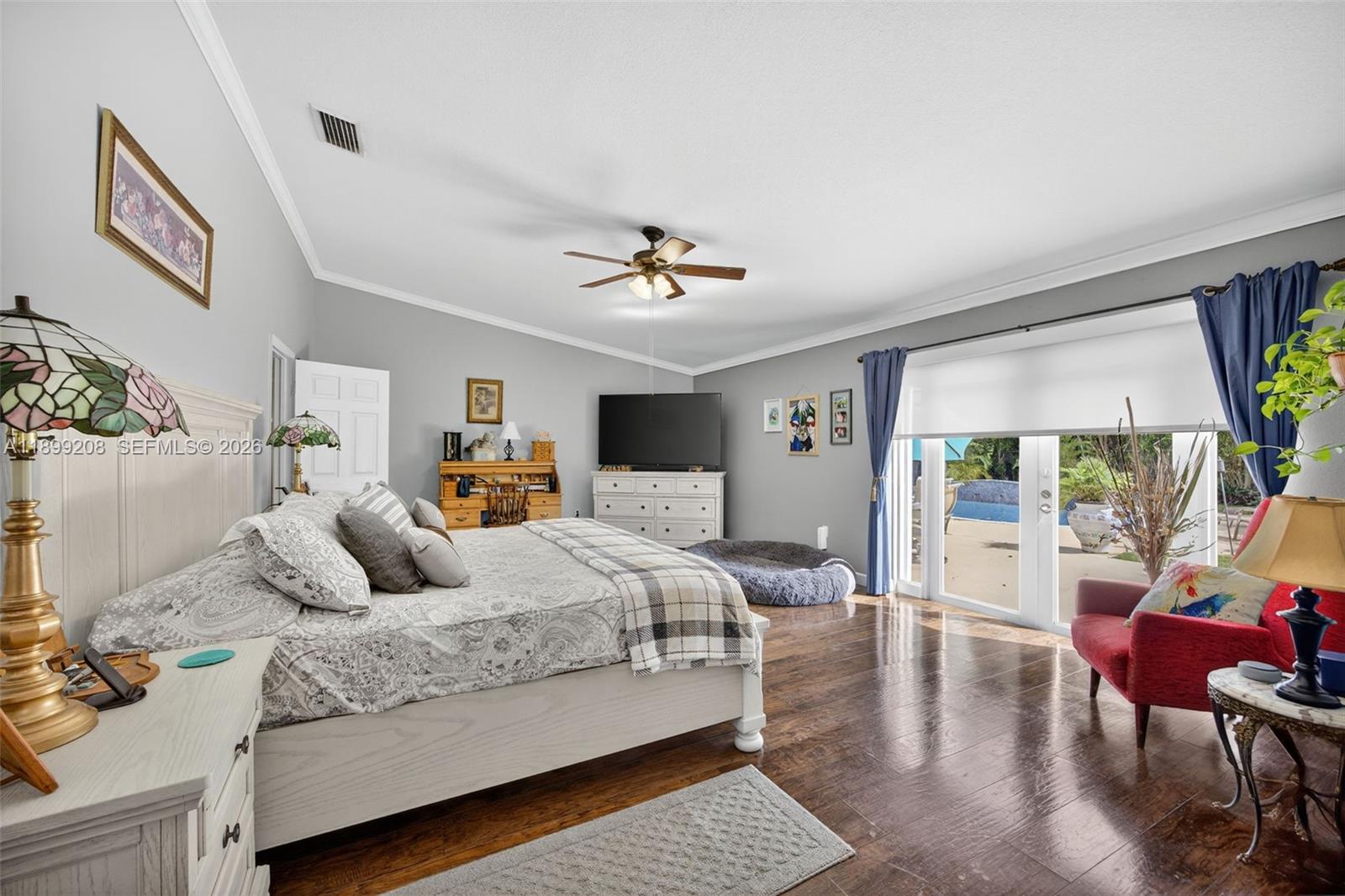 28241 Southwest 157th Court Homestead, FL 33033 - Photo 27 of 52 a bedroom with a large bed and a chandelier
