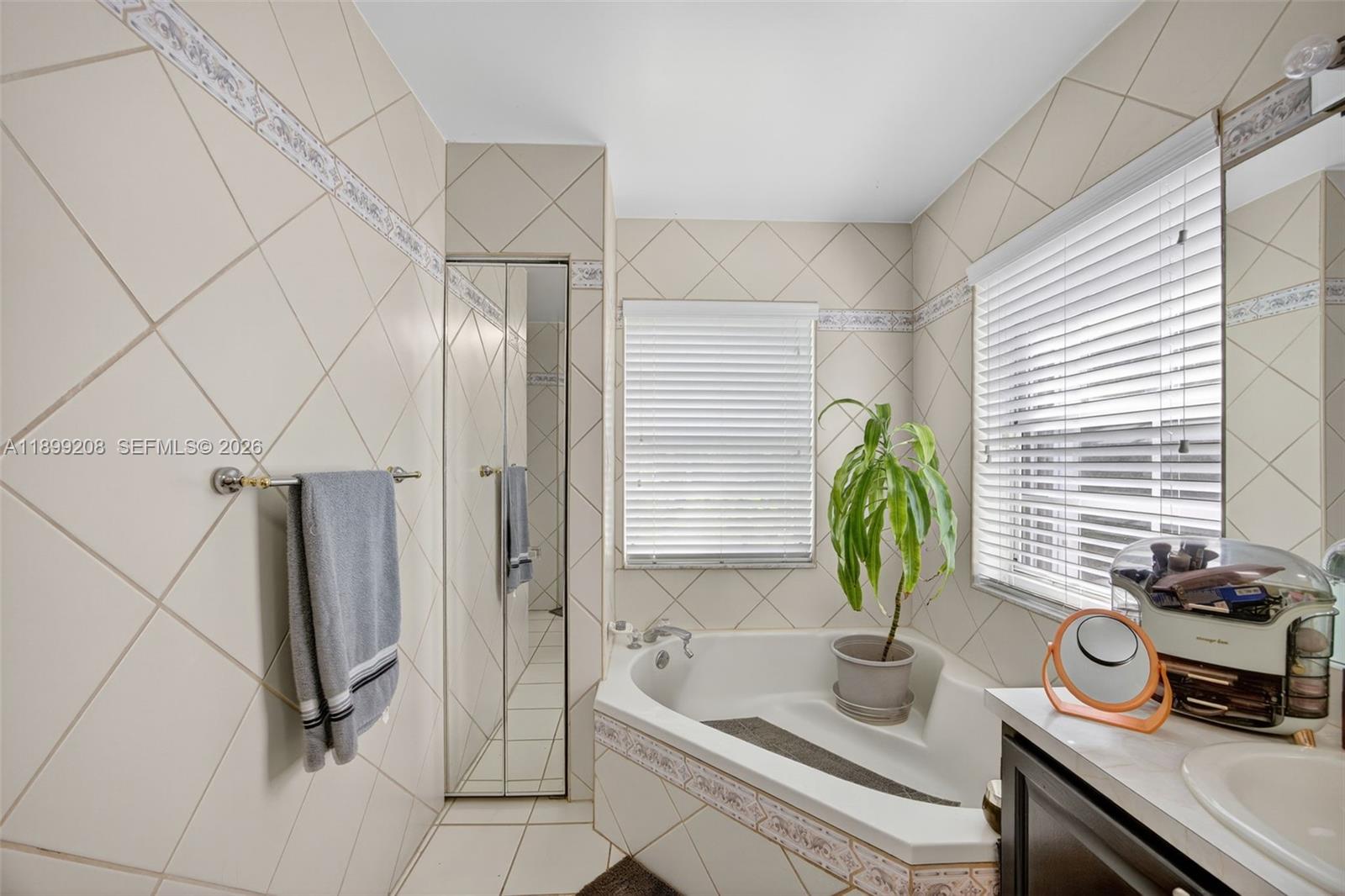 28241 Southwest 157th Court Homestead, FL 33033 - Photo 29 of 52 a bathroom with a bathtub a sink a window and a shower