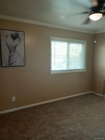 an empty room with a window and a fan