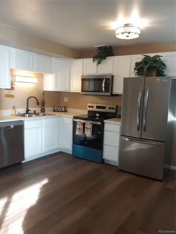 a kitchen with stainless steel appliances granite countertop a refrigerator a stove a sink dishwasher and a refrigerator