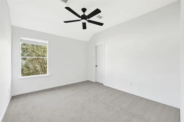 an empty room with a window and a fan