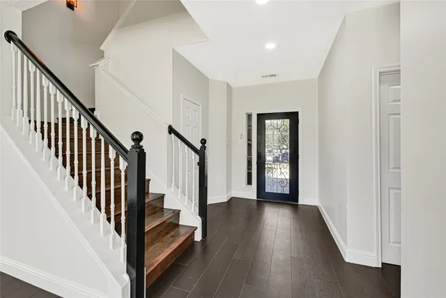 a view of a hallway with wooden floor and stairs