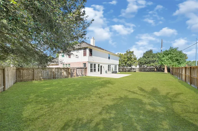 a view of a house next to a yard with plants and trees