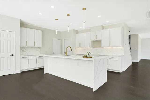 a kitchen with stainless steel appliances sink refrigerator and white cabinets