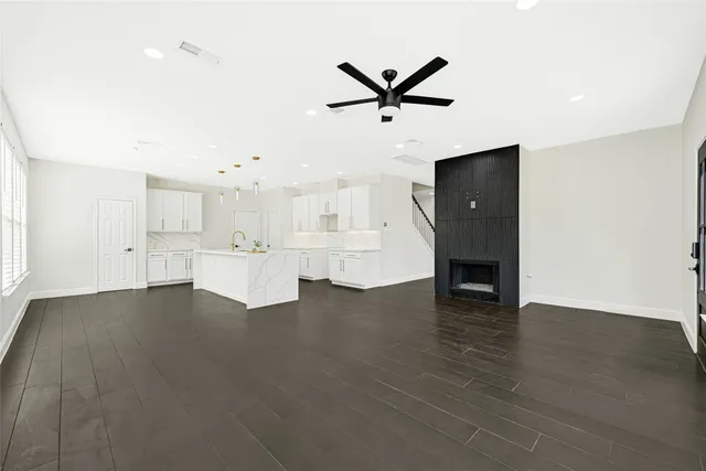 a view of empty room with wooden floor and ceiling fan