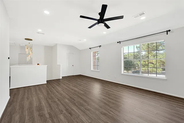 a view of empty room with wooden floor and window