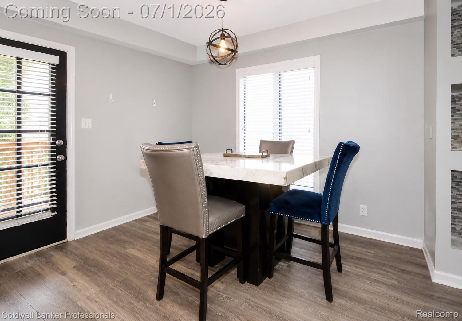 1168 Vernier Road Grosse Pointe, MI 48236 - Photo 16 of 32 Dining area featuring a modern light fixture, wood-finish flooring, and a white window with blinds