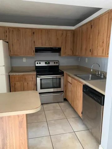 a kitchen with a sink a stove and cabinets