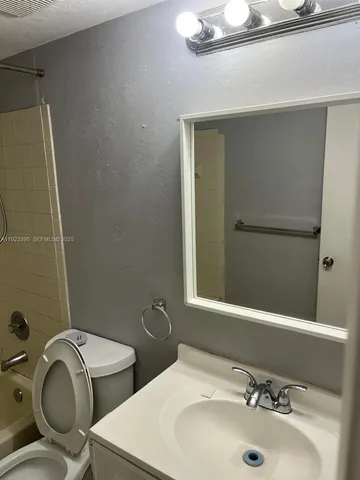 a bathroom with a sink a toilet and mirror