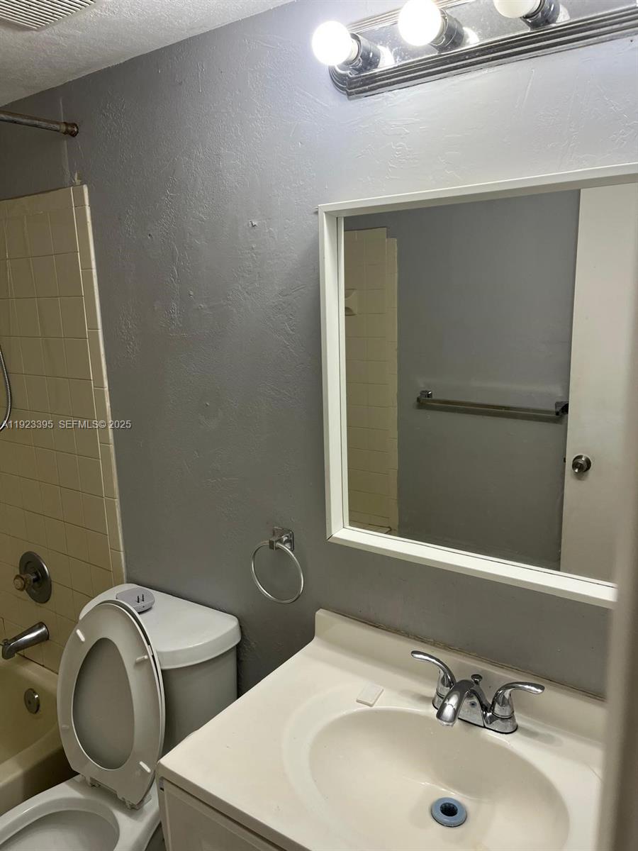 20320 Northeast 3rd Court, Unit 7 Miami, FL 33179 - Photo 6 of 10 a bathroom with a sink a toilet and mirror