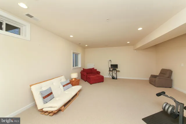 a view of a roof deck with table and chairs under an umbrella with a small yard