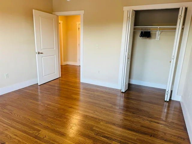 an empty room with wooden floor and closet