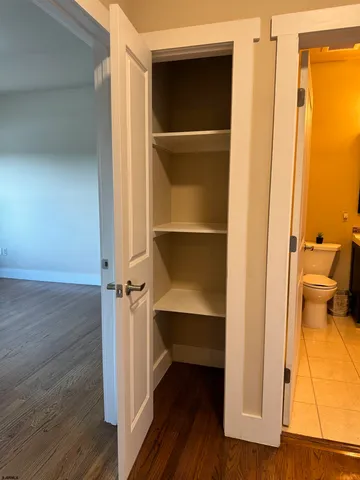 a view of walk in closet with wooden floor