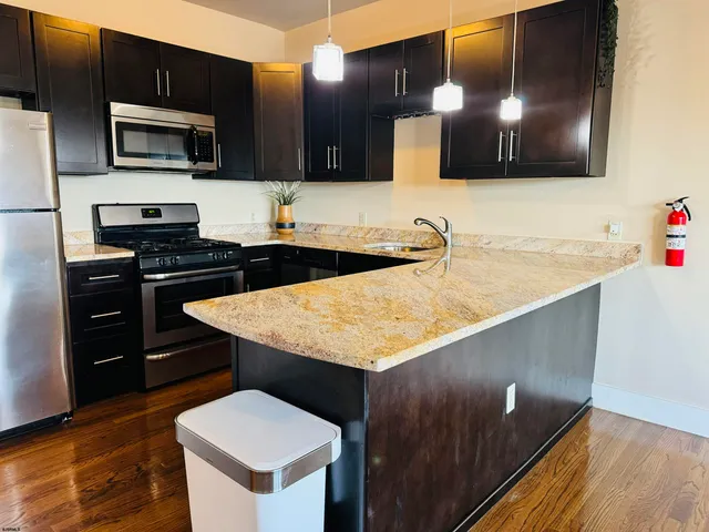 a kitchen with stainless steel appliances granite countertop a sink stove and microwave
