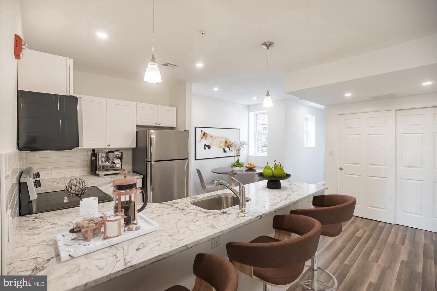 2630 Ridge Avenue, Unit 1 Philadelphia, PA 19121 - Photo 1 of 13 a kitchen with stainless steel appliances kitchen island granite countertop a sink and cabinets