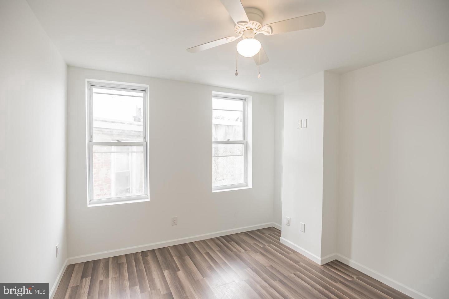 2630 Ridge Avenue, Unit 1 Philadelphia, PA 19121 - Photo 10 of 13 an empty room with wooden floor ceiling fan and windows