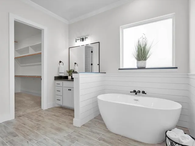 a white bath tub sitting next to a bathroom sink