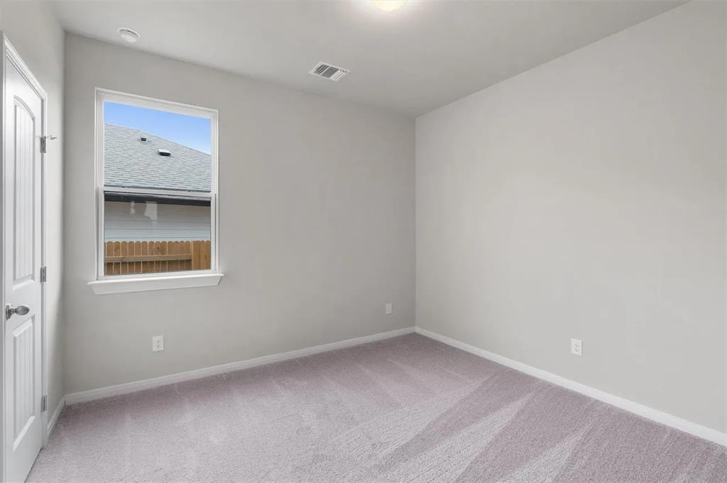 332 Stellar Wind Drive Georgetown, TX 78628 - Photo 18 of 29 A well-lit bedroom offering a blank canvas for personalization.