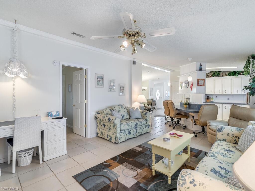 114 Audubon Road Naples, FL 34114 - Photo 14 of 34 a living room with furniture and a chandelier