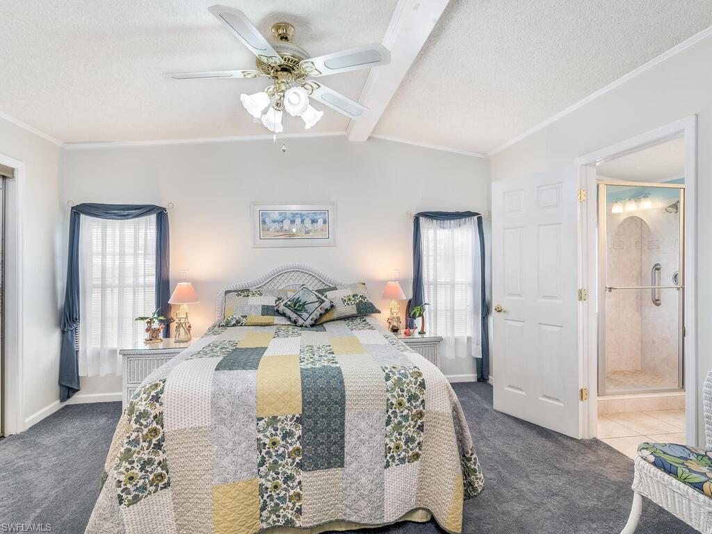 114 Audubon Road Naples, FL 34114 - Photo 15 of 34 a bedroom with a large bed and a chandelier