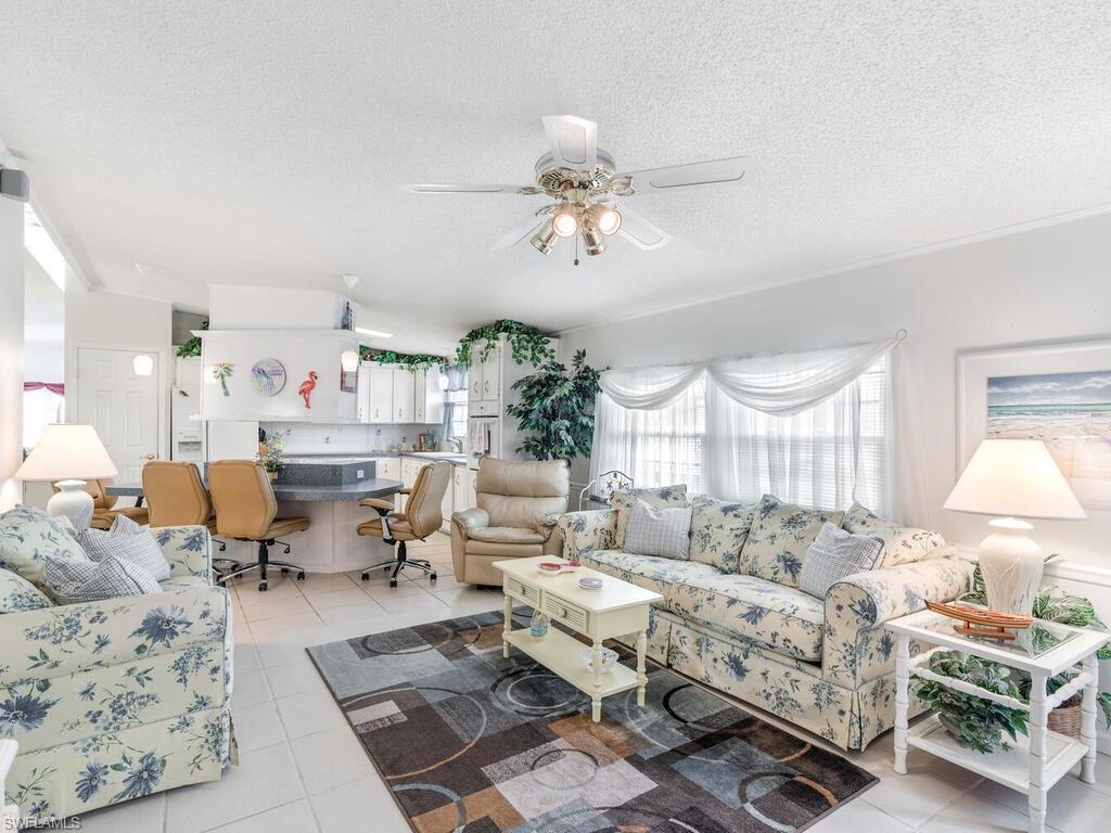 114 Audubon Road Naples, FL 34114 - Photo 18 of 34 a living room with lots of furniture and a chandelier