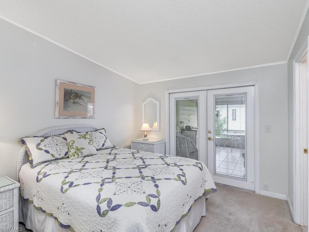 114 Audubon Road Naples, FL 34114 - Photo 19 of 34 a bedroom with a bed and glass door