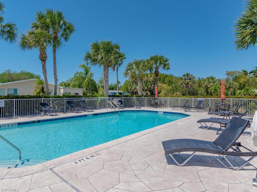114 Audubon Road Naples, FL 34114 - Photo 30 of 34 a view of a swimming pool with a patio and a garden