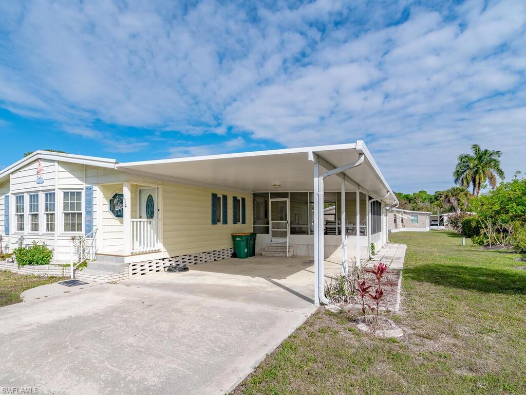 114 Audubon Road Naples, FL 34114 - Photo 4 of 34 a front view of a house with a garden and patio