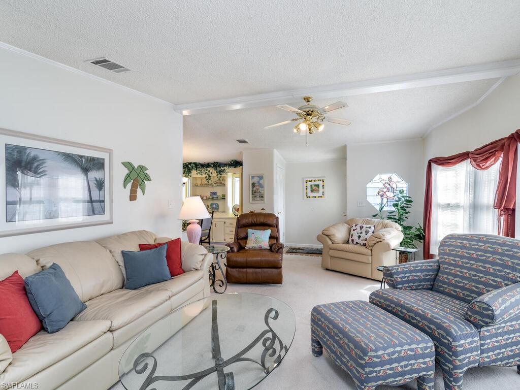 114 Audubon Road Naples, FL 34114 - Photo 7 of 34 a living room with furniture and a chandelier