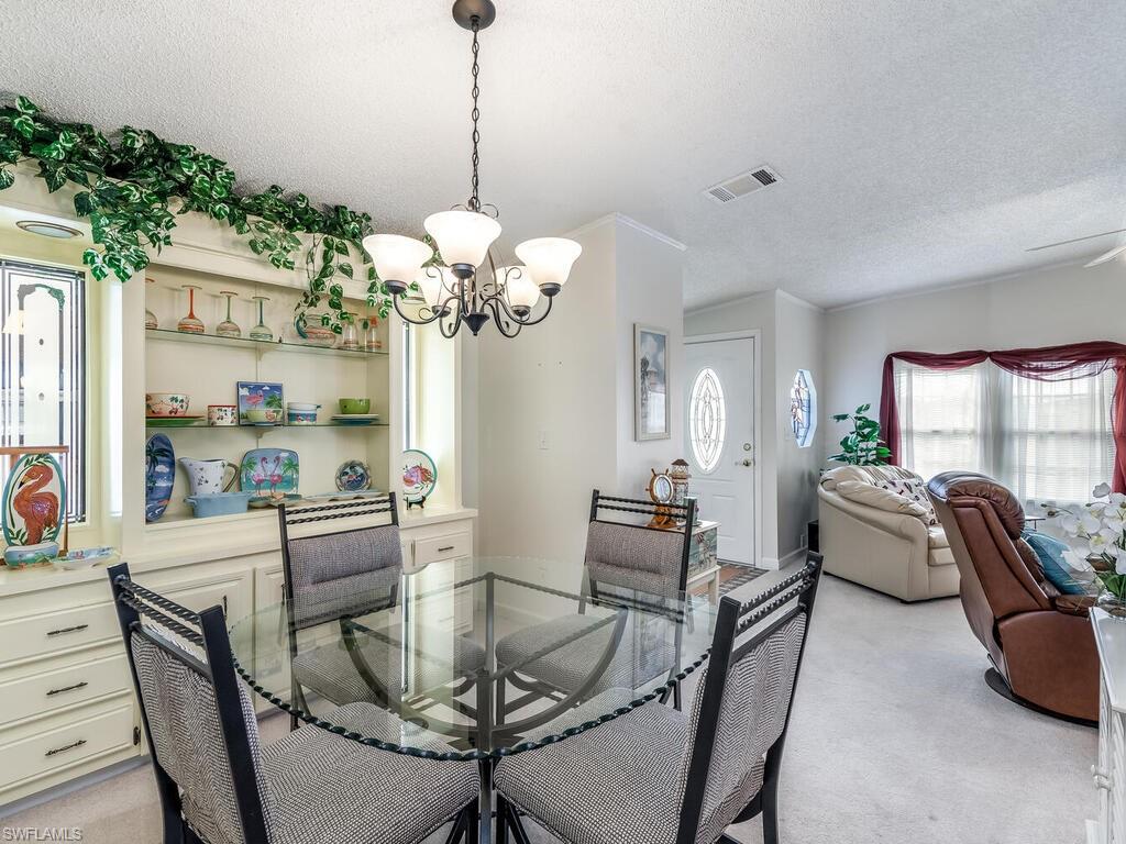 114 Audubon Road Naples, FL 34114 - Photo 8 of 34 a dining room filled chandelier and wooden floor