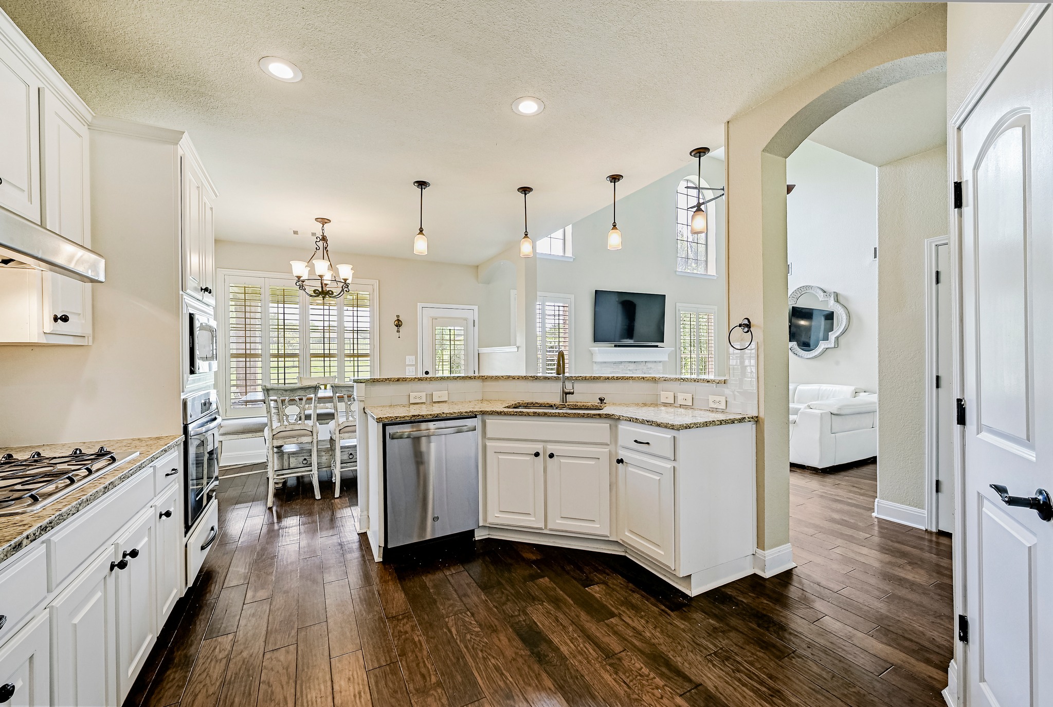 2408 Amen Corner Road Pflugerville, TX 78660 - Photo 15 of 40 Kitchen featuring white cabinetry, granite countertops, stainless steel appliances, dark wood-finish flooring, and recessed lighting