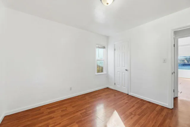 a view of a room with wooden floor and white walls