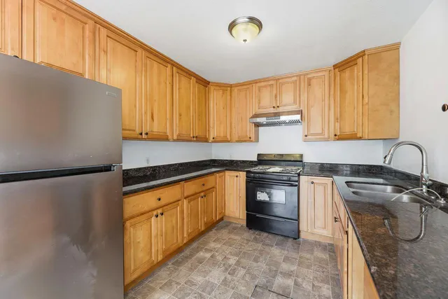 a kitchen with stainless steel appliances granite countertop a stove a sink dishwasher and a refrigerator