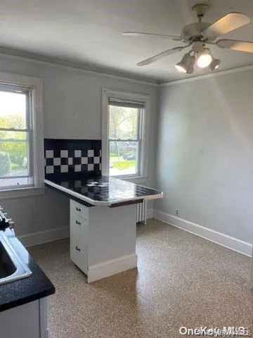 a kitchen with granite countertop a stove a sink and a window