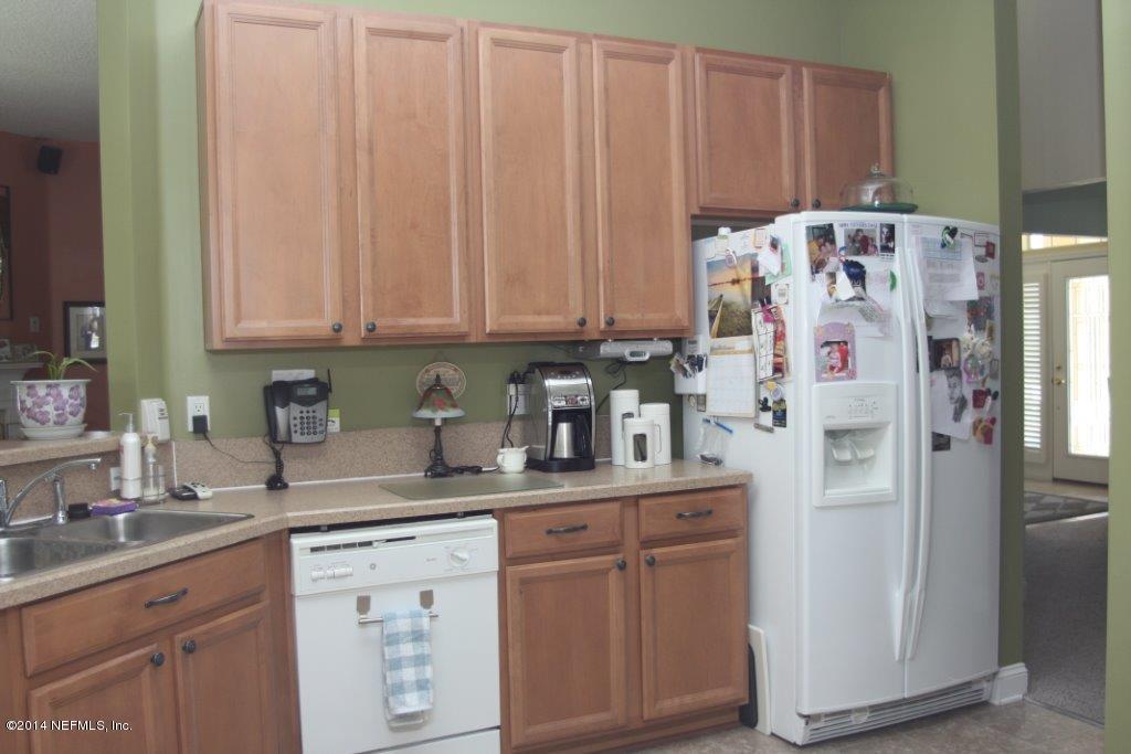97178 Castle Ridge Drive Yulee, FL 32097 - Photo 6 of 14 a kitchen with stainless steel appliances granite countertop a refrigerator and a sink