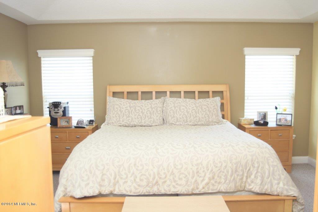 97178 Castle Ridge Drive Yulee, FL 32097 - Photo 9 of 14 a large bed sitting in a bedroom next to a window
