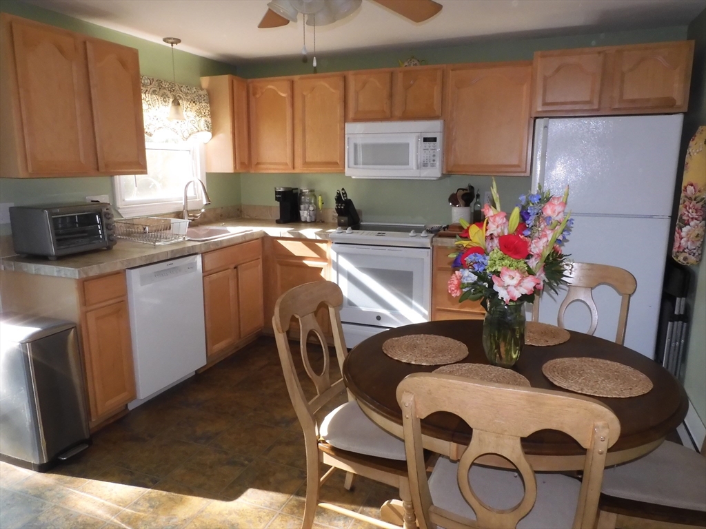 134 Old Ferry Road, Unit A Haverhill, MA 01830 - Photo 7 of 24 a kitchen with stainless steel appliances granite countertop a dining table chairs and a refrigerator