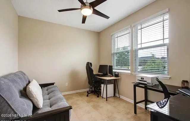 a view of a livingroom with workspace and a window