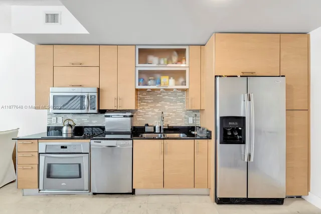 a kitchen with stainless steel appliances a refrigerator sink and cabinets