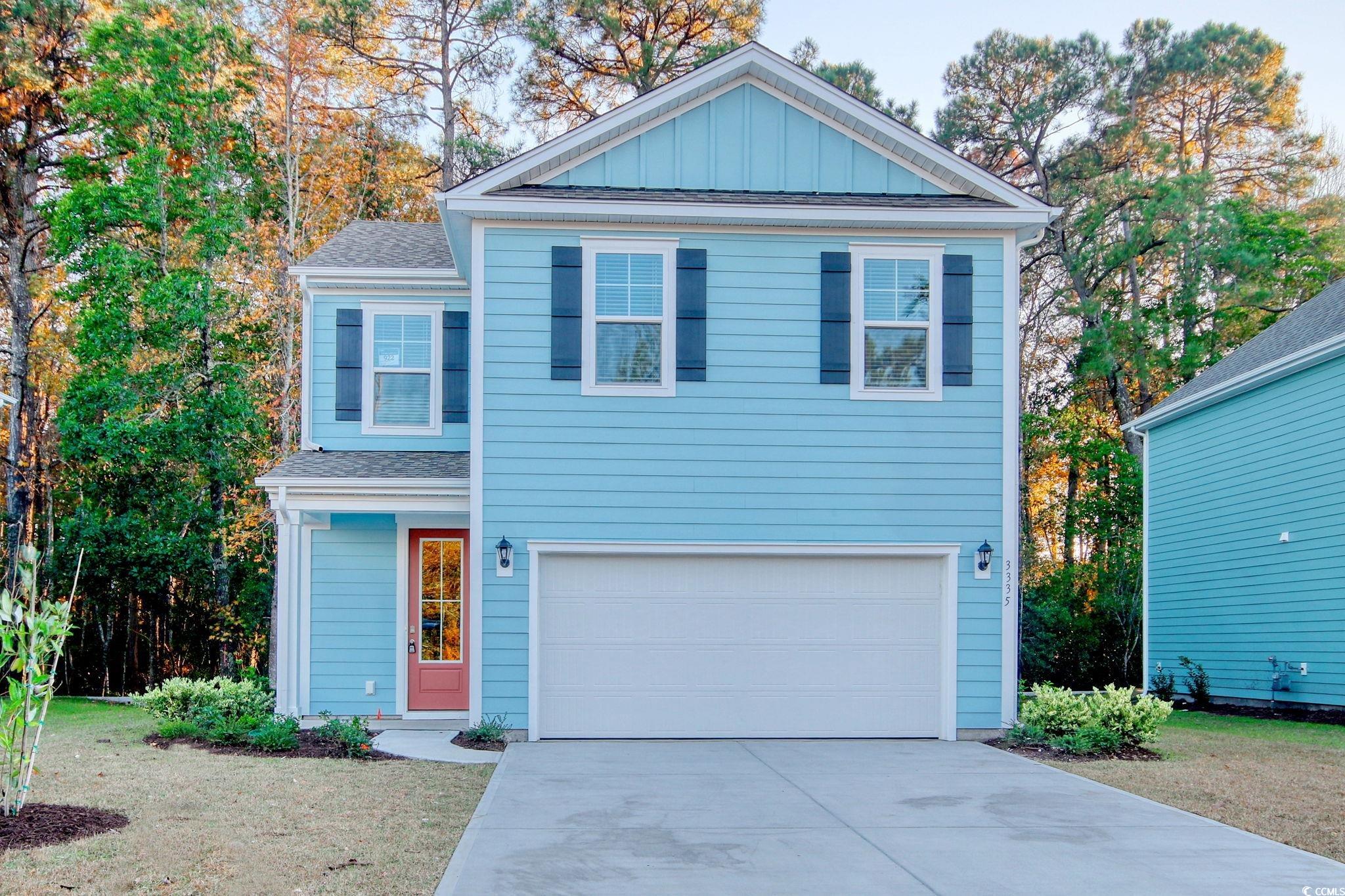 View of front of home featuring board and batten siding, driveway, roof with shingles, and a garage