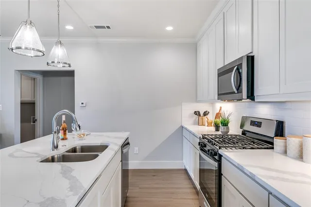 a kitchen with kitchen island granite countertop a sink and a stove top oven