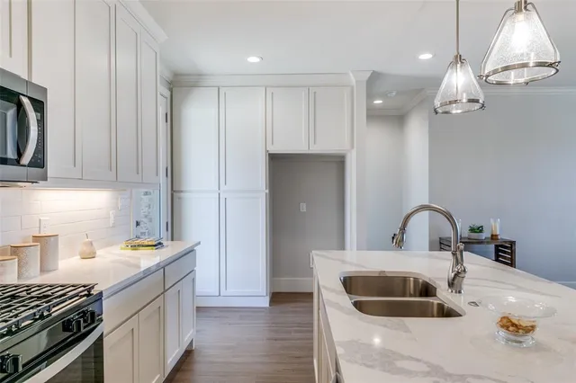 a kitchen with stainless steel appliances a sink stove and refrigerator