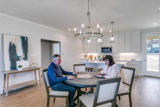 a view of a dining room and livingroom with furniture wooden floor a chandelier