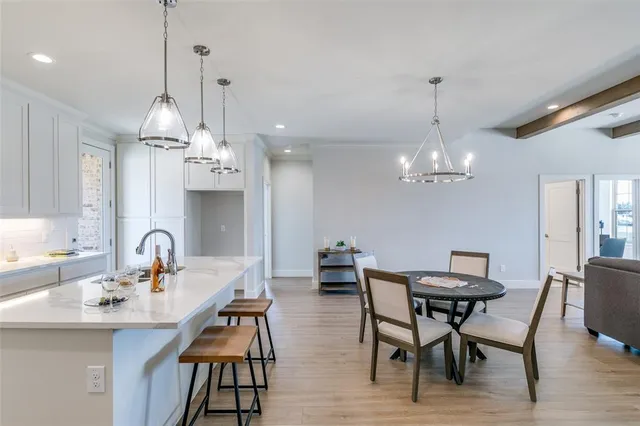 a kitchen with stainless steel appliances a table chairs and chandelier