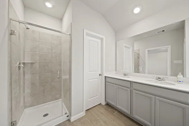 a bathroom with a double vanity sink mirror and shower