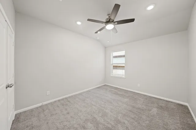 an empty room with windows and fan