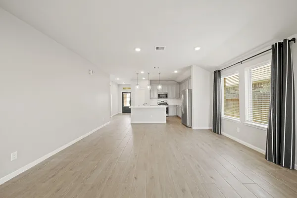 a view of a big room with wooden floor and windows