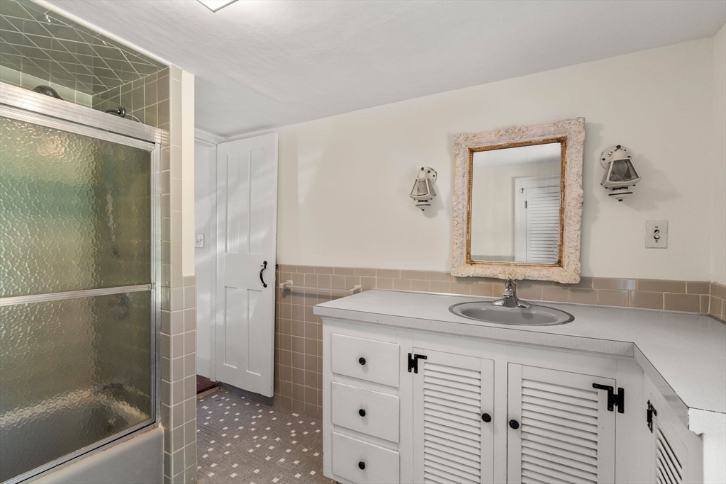 495 Edmands Road Framingham, MA 01701 - Photo 38 of 39 a bathroom with a granite countertop sink a mirror and shower