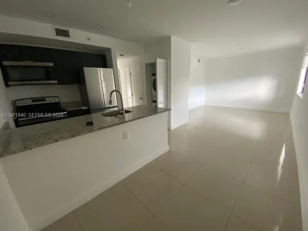 a kitchen with stainless steel appliances a sink a stove a microwave and a refrigerator